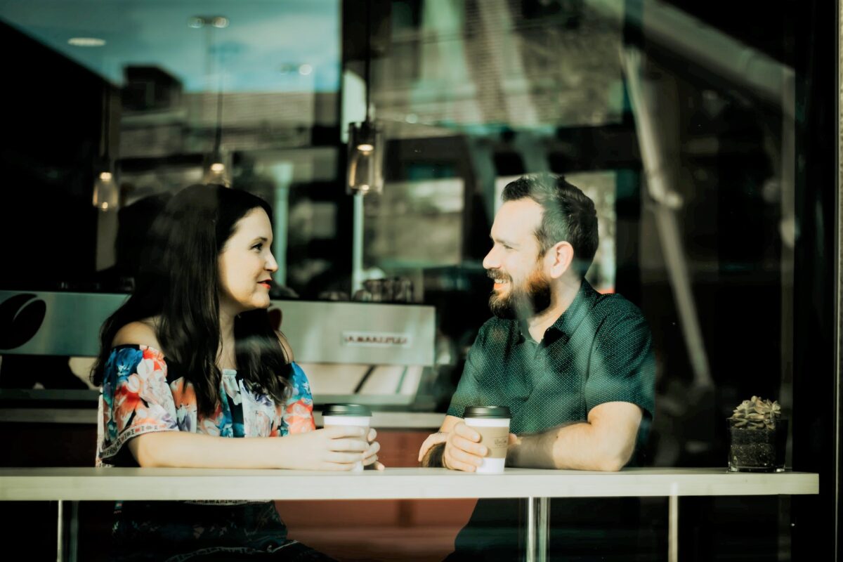 Dicas para não ficar sem assunto no primeiro encontro: casal conversando em um café
