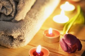 Como enlouquecer um homem na cama: velas, toalha e flor num ambiente propício para uma massagem corporal