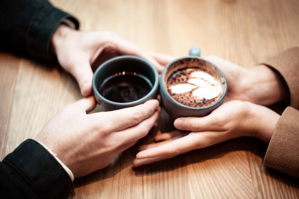 Como encontrar o amor depois dos 40: casal com xícaras de café no primeiro encontro