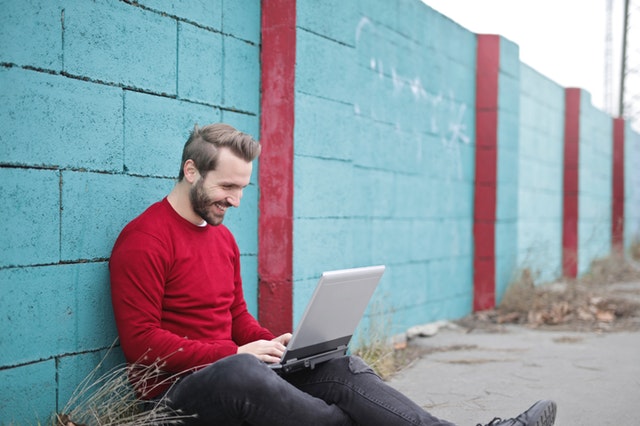 Namoro virtual da certo: homem feliz teclando com alguém que conheceu pela internet