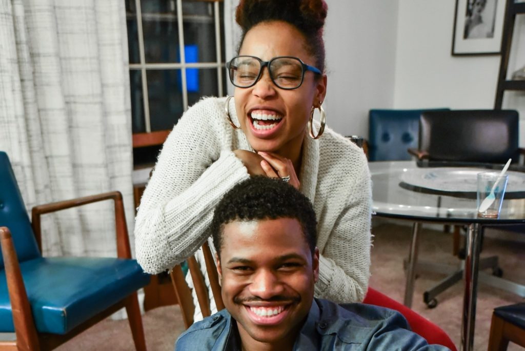 Como conquistar um homem - faca-o sorrir: cena de uma mulher apoiada sobre a cabeça de um homem e os dois sorrindo
