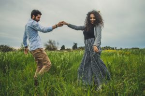 Autoestima baixa - como transformá-la em alta: casal dançando livremente sobre a grama
