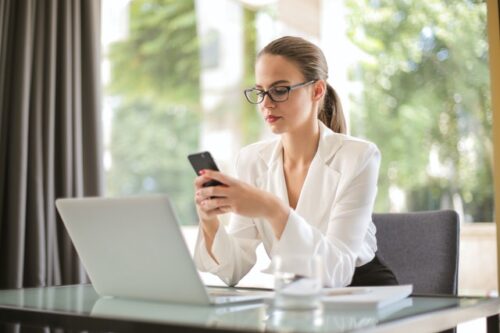 Ele terminou mas continua falando comigo: mulher trabahando e olhando o celular