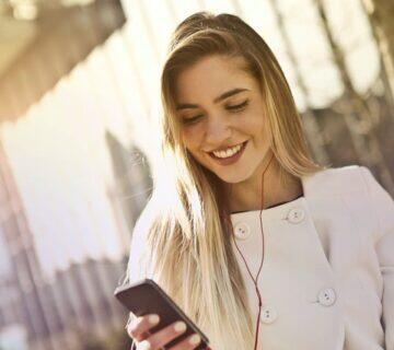 namoro virtual: moça olhando para o celular e sorrindo