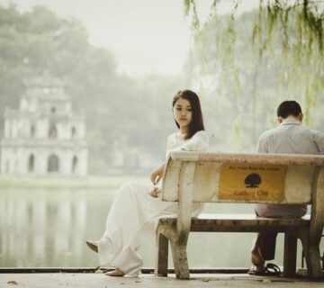 solidão a dois: casal num banco, cada um olhando para um lado